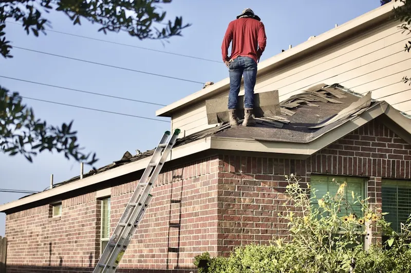 Professional roofer working on a residential roof in Sagamore Village